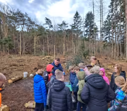 Leerlingen helpen nieuw bos planten achter begraafplaats in Een